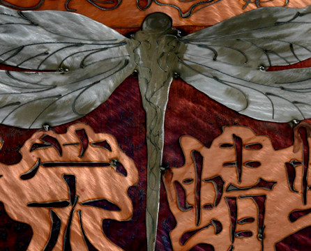 Body of dragonfly flanked by bright characters.