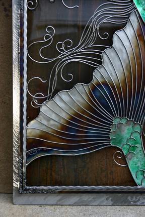A look at a portion of the fin and hair against the marbled patina metal. 
